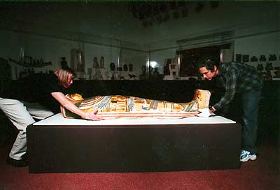 museum preparators moving mummy