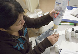 Nancy Nguyen, a fourth-year anthropology major, fills up shampoo bottle for free hygiene kits. 